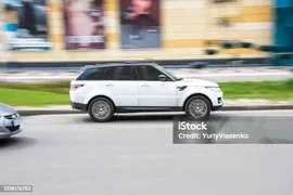 Белый Land Rover Range Rover Sport Автомобиль Движется По Улице — стоковые фотографии и другие картинки Land Rover