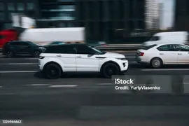 Белый Land Rover Range Rover Evoque Автомобиль Движется По Улице — стоковые фотографии и другие картинки Land Rover